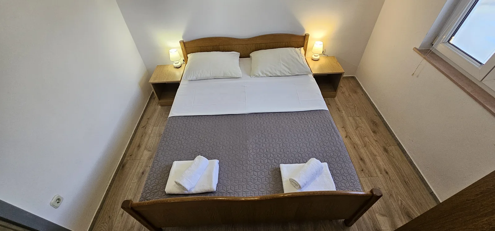 Spavaća soba s pripremljenim ručnicima u Apartmanima Jelena